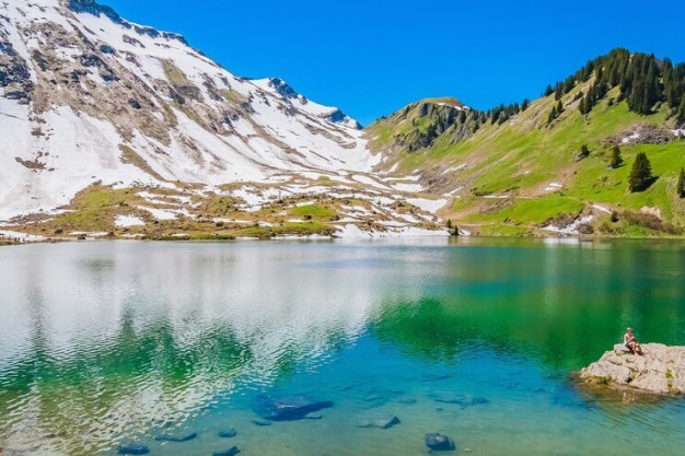 A panoramic view of the Swiss Alps with a clear blue lake